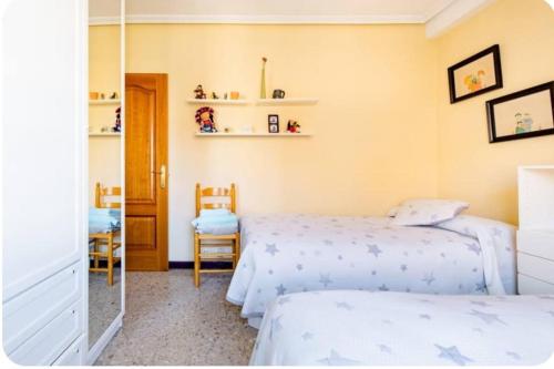 une chambre avec deux lits et un miroir dans l'établissement Se alquila una habitación doble con aire acondicionado, à Valence