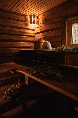 a kitchen in a wooden cabin with a stove at Pirts Muzejs in Loja