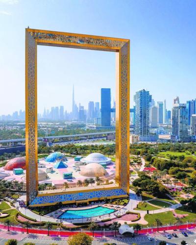 an overhead view of a city with a large frame at Classic Capsule Holiday Homes in Dubai