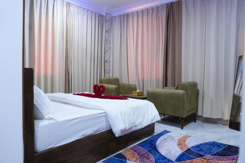 a bedroom with a bed with a red ribbon on it at hotel rose garden فندق روز جاردن in Duqm
