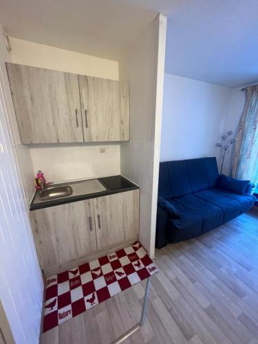 - un salon avec un canapé bleu et un lavabo dans l'établissement Aiguille 2, à Chamonix-Mont-Blanc