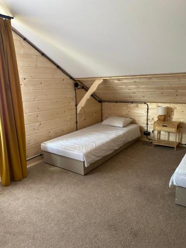 a bedroom with a bed in a wooden room at Villa SPA in Czerwona Góra