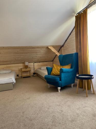 a room with a blue chair and a bed at Villa SPA in Czerwona Góra