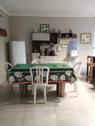 a kitchen with a table and chairs with a green table cloth at Casa a Beira Mar em Itamaracá in Itamaracá