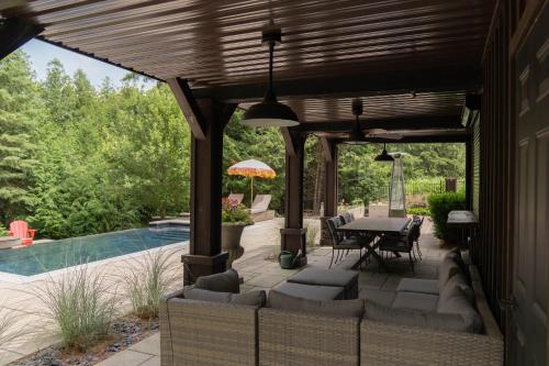 eine Terrasse mit Tisch und Stühlen neben einem Pool in der Unterkunft Cozy Private Suite with Year-Round Hot Tub in Elora