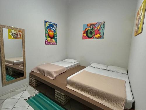 a room with two beds and a mirror at Zizi Home Vibes in Chapada dos Guimarães