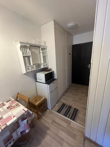 Cette chambre comprend une cuisine équipée d'un four micro-ondes et d'une table. dans l'établissement Aiguille 2, à Chamonix-Mont-Blanc