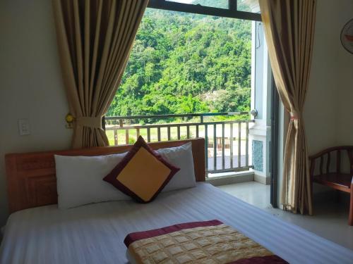 a bedroom with a bed and a large window at Ba Be Lake - Nhà Nghỉ Thư Nhạc in Bak Kan