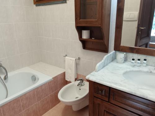 a bathroom with a sink and a tub and a toilet at Le Terrazze di katia rooms in Riomaggiore
