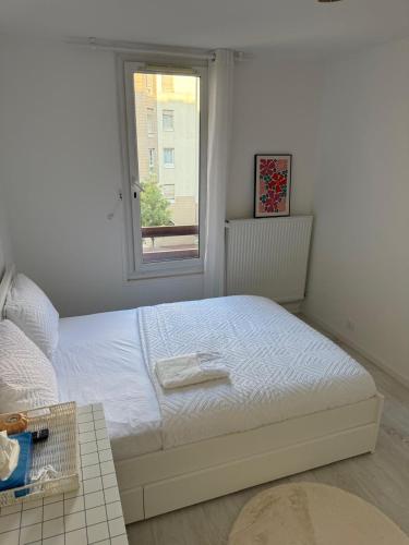 a white bed in a room with a window at SamShen in Créteil