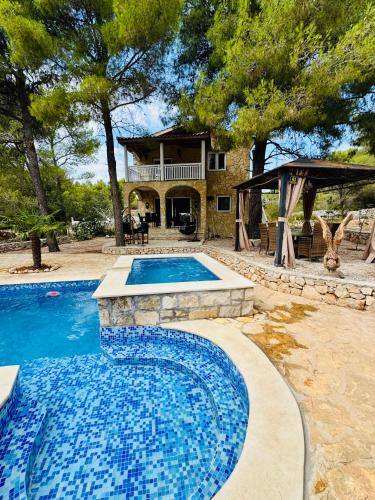a swimming pool in front of a house at Villa Paradisio Ruheoase - Pool - Klima - Küche - Parken in Milna