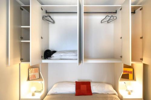 a small bedroom with a bed and some shelves at Residenza Cavour - Appartamento A in Tirano