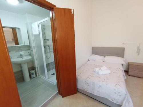 a bedroom with a bed and a shower and a sink at Monolocale Libertà in Reggio Calabria