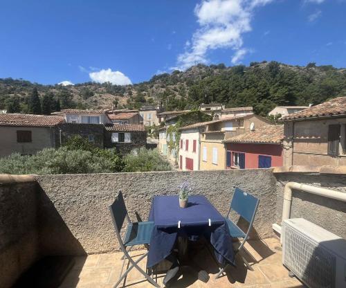 a table and two chairs on a balcony with a mountain at Maison provençale de village avec terrasse - Golfe de Saint-Tropez, Côte d'Azur in La Garde-Freinet
