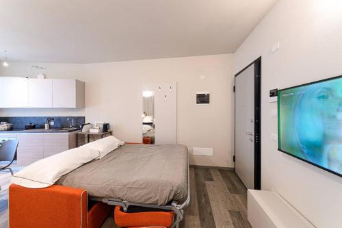 a room with a bed and a flat screen tv at Residenza Cavour - Appartamento B in Tirano