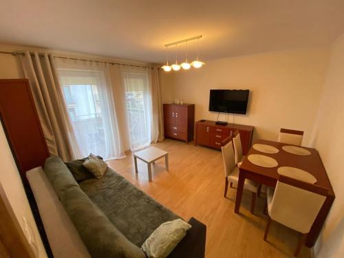 a living room with a couch and a table at Nowy apartament OHIVI ŚWINOUJŚCIE in Świnoujście