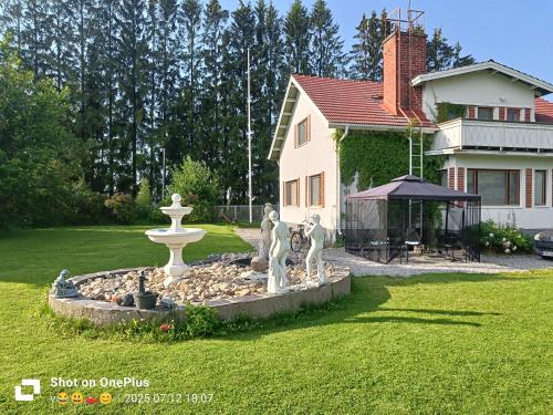 a fountain in a yard in front of a house at Nina`s GuestHouse, Jämsä City, 160 m2, Include x2 Himos Ski Pass in Jämsä