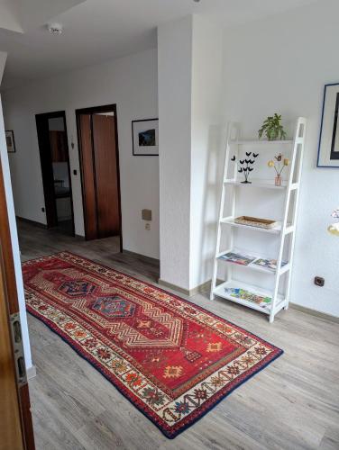 a room with a rug and a white book shelf at Harzflair am Hausberg in Bad Lauterberg