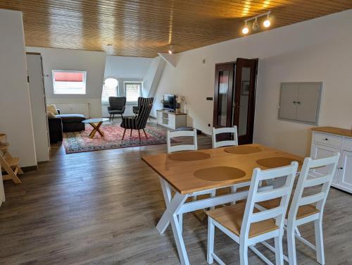 a dining room and living room with a table and chairs at Harzflair am Hausberg in Bad Lauterberg