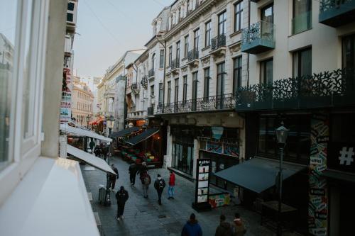 a group of people walking down a street with buildings at Old Town Cozy Suites Smârdan - Pumo Properties in Bucharest
