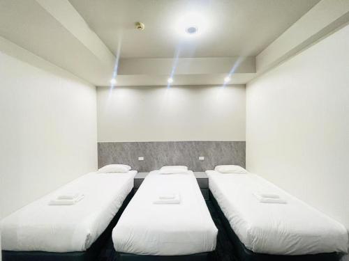 three beds in a room with lights on the ceiling at Hotel Arashi Shinsaibashi No001 in Osaka