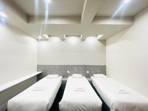 a row of beds in a room with lights at Hotel Arashi Shinsaibashi No001 in Osaka