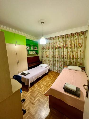 a room with two beds and a book shelf at Stylish Modern Maisonette in Thessaloniki