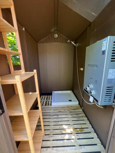 Cette petite chambre dispose d'une échelle et d'un réfrigérateur. dans l'établissement Les Hulottes, à Le Vrétot