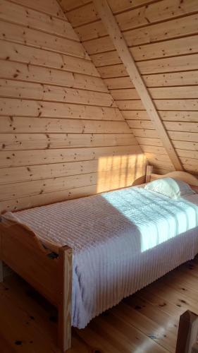 una camera da letto con un letto in una stanza di legno di Agroturystyka dzika łąka Słonów Domek 
