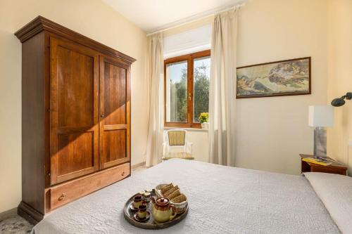 a bedroom with a bed with a wooden cabinet and a plate of food at Villa Fiorenzani in Radicondoli