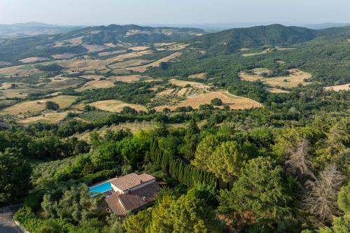 an aerial view of a villa in a valley with trees at Villa Fiorenzani in Radicondoli