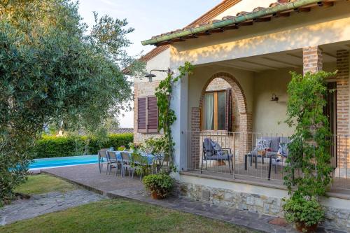 a house with a balcony with a table and chairs at Villa Fiorenzani in Radicondoli