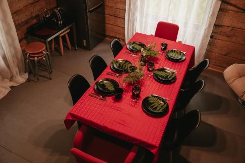 a red table with gold plates on top of it at Pirts Muzejs in Loja