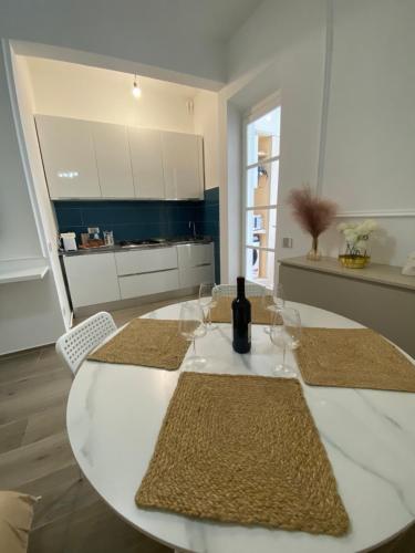 a white table with glasses and a bottle of wine at Appartamento Olivia in Viareggio