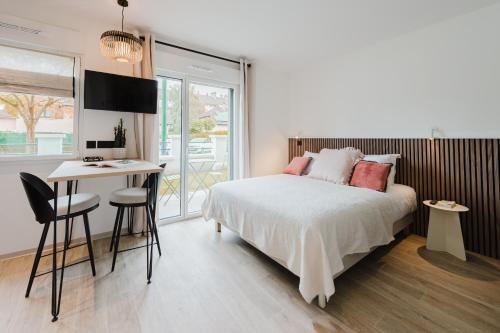 a bedroom with a bed and a desk and a table at Appart Hotel Neostelia in Annecy