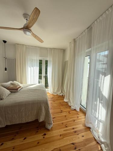 ein Schlafzimmer mit einem Bett und einem Deckenventilator in der Unterkunft powiew - b&b pensjonat noclegi Świnoujście - Unterkunft Swinemünde - guesthouse tennis garden breakfast at baltic sea in Świnoujście