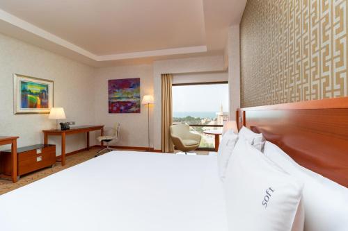 a hotel room with a bed and a desk at Holiday Inn - Suites Kuwait Salmiya by IHG in Kuwait