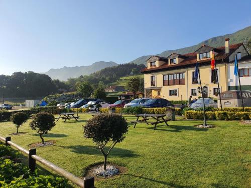 a park with trees in the grass in front of a building at Casa de Aldea El Frade in Ribadesella