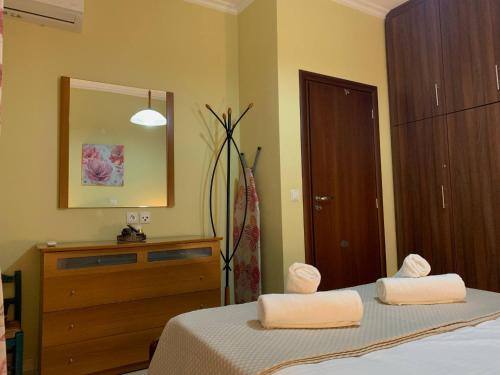 a bedroom with a bed and a dresser with two towels at Maria's House in Karpathos Town