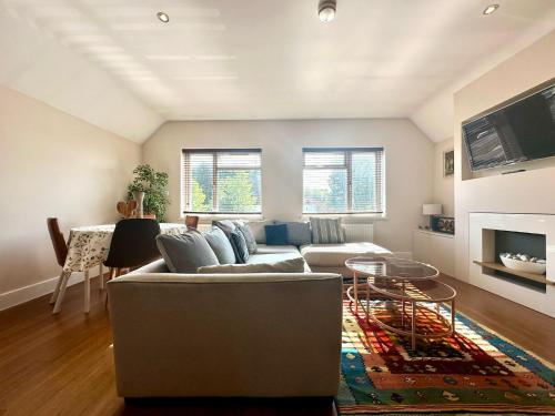 a living room with a couch and a table at Stylish 2 Bed Apartment sleeps 4 in Yarnton