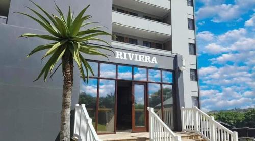 a palm tree in front of a building at South Coast Riviera 203 in Port Shepstone