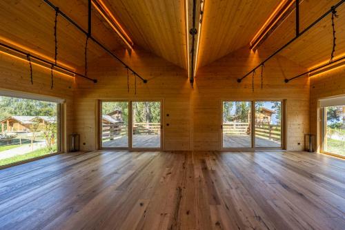 an empty room with wood floors and windows at MAD Retreat Hotel in Nendaz