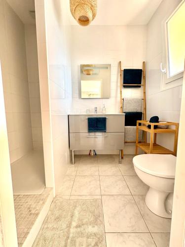 une salle de bain avec un lavabo et des toilettes dans l'établissement Chez Audrey - Charmante villa - Jardin & Clim, à Loupian