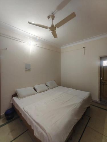 a bedroom with a bed with a ceiling fan at Oyo The Jhunjhunu Palace Hotel in Jhunjhunūn