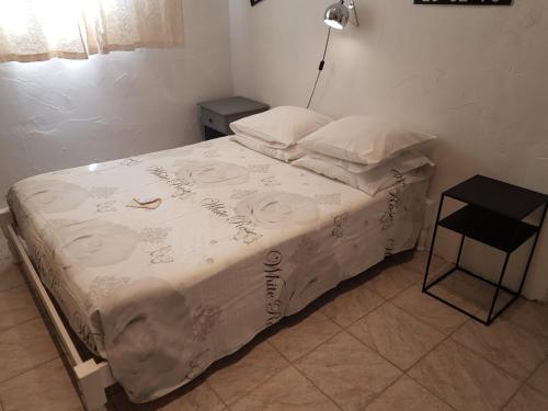 a bedroom with a bed with a white comforter at Le gîte des chambres de la grange in Cherval