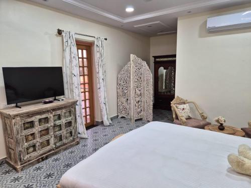 una camera da letto con un letto e una TV a schermo piatto di The Sunrise Retreat a Jodhpur