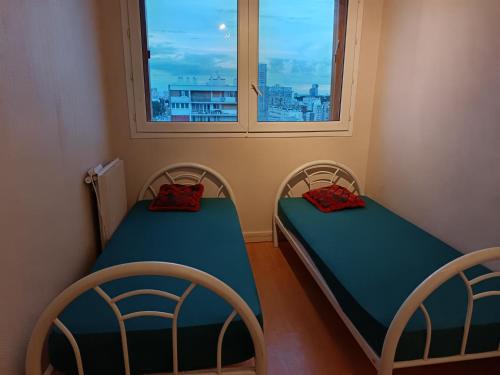 deux lits dans une chambre avec une fenêtre dans l'établissement Joli appartement entier, à Vitry-sur-Seine