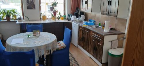 a kitchen with a table and blue chairs in a kitchen at Gasthaus Schmidt's in Neuhaldensleben