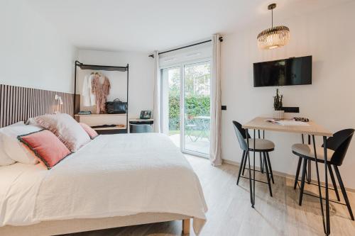 a bedroom with a bed and a table and a desk at Appart Hotel Neostelia in Annecy