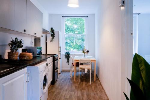 a kitchen with a table and a window in it at London Bridge Stays in London